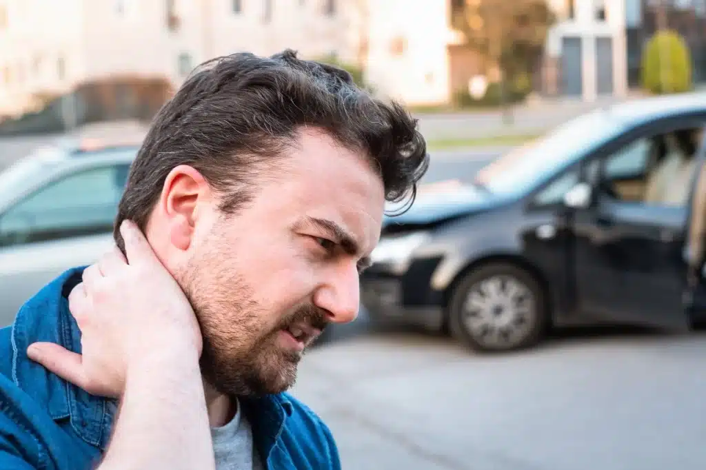 Man holding neck in pain after car accident.