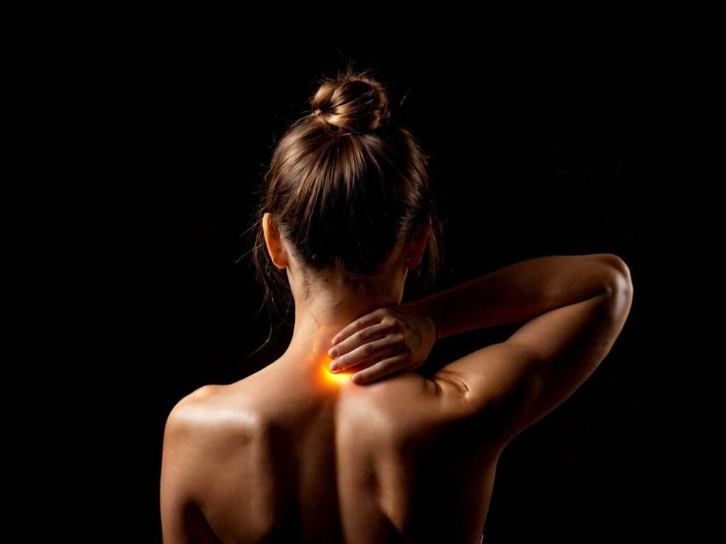 Woman touching neck with pain, dark background